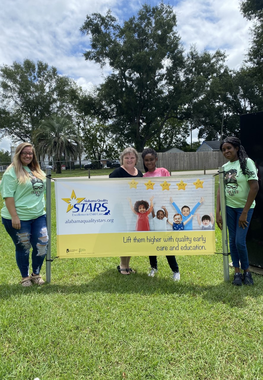 STAR Rated Providers standing outside their center with their Alabama Quality STARS Banner