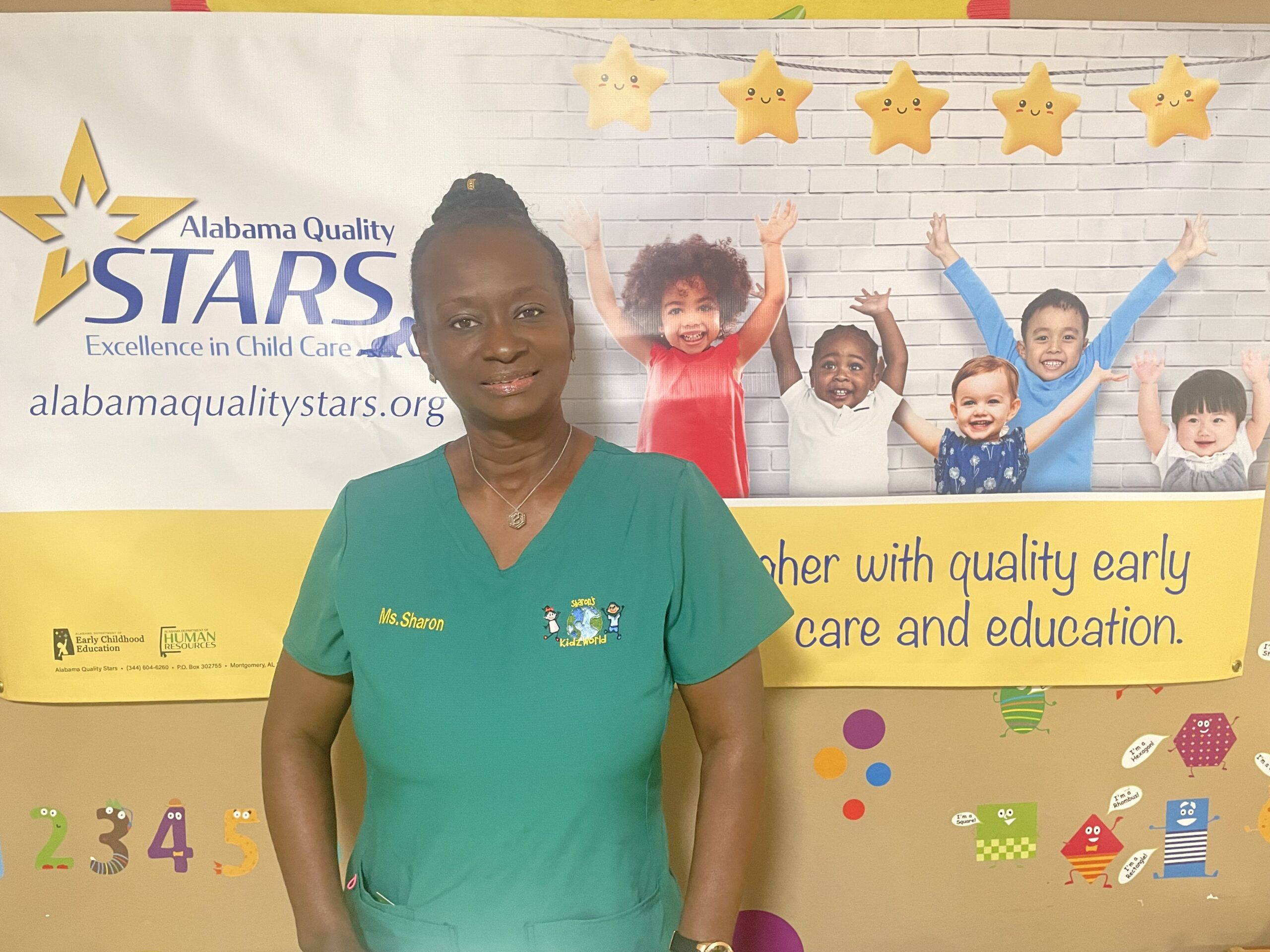 STAR Rated home provider standing in front of her Alabama Quality STARS Banner