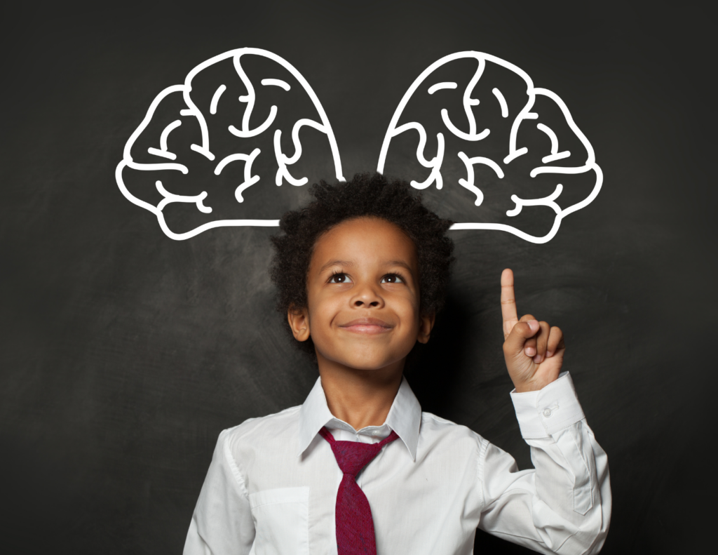 a Kid with a drawing of a brain in the background on a chalkboard