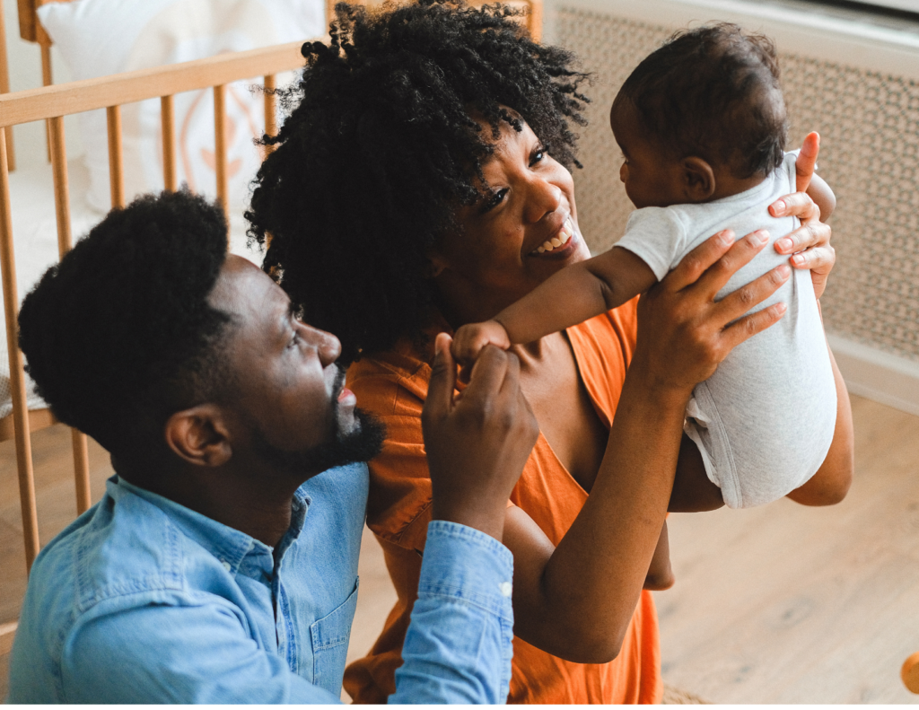 A mother and father holding thier baby